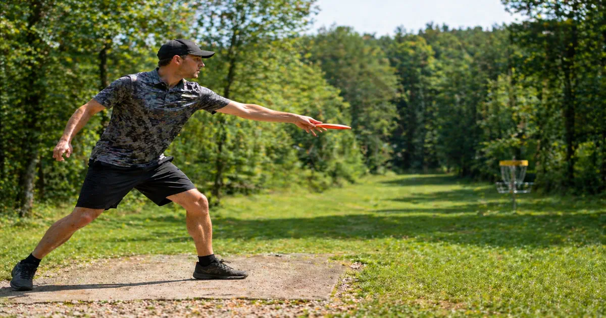 A disc golfer throwing a forehand sidearm shot with two-finger grip