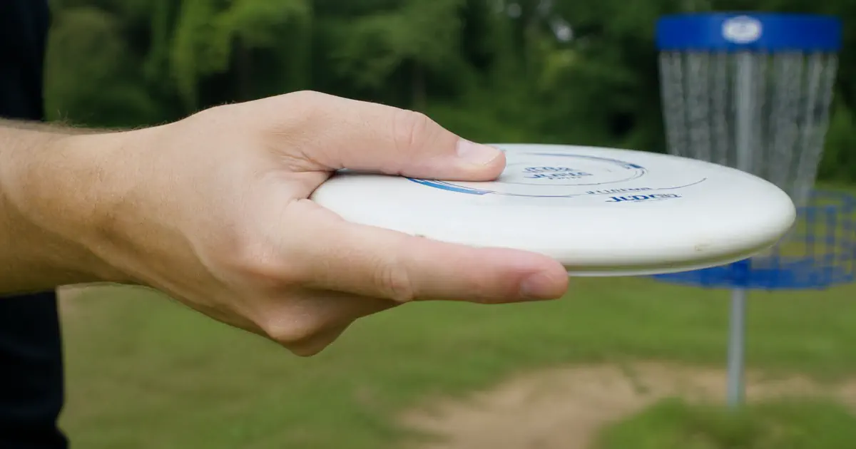 Disc golf push putt grip — fingers spread across the underside of the disc in a fan grip